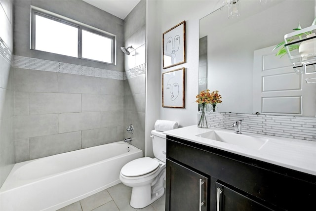 full bathroom featuring vanity, tile patterned floors, tiled shower / bath combo, toilet, and tasteful backsplash