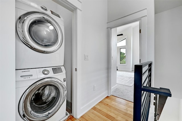 washroom featuring light hardwood / wood-style floors and stacked washer and clothes dryer