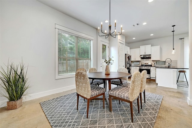 dining space featuring sink and an inviting chandelier