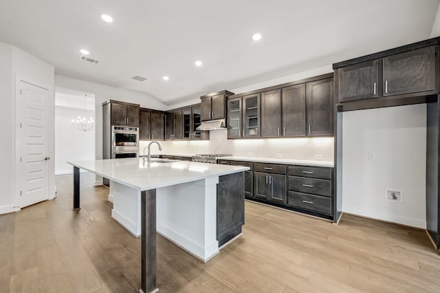 kitchen with visible vents, a sink, light wood-style floors, and baseboards