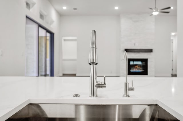 kitchen featuring light countertops, ceiling fan, a lit fireplace, and recessed lighting