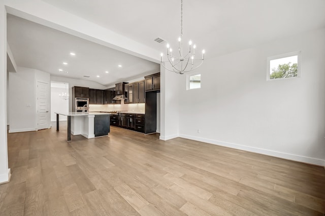 unfurnished living room featuring baseboards, a notable chandelier, and a wealth of natural light