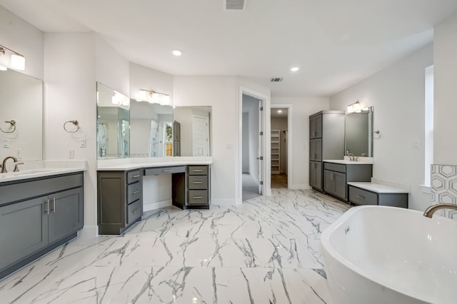 full bathroom featuring recessed lighting, a freestanding tub, and a sink