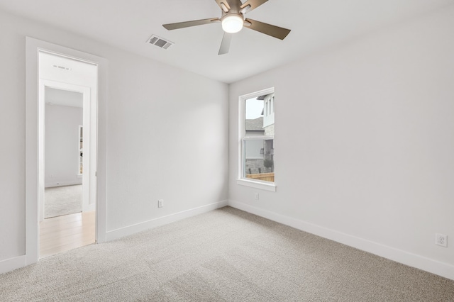 spare room featuring a ceiling fan, baseboards, visible vents, and carpet