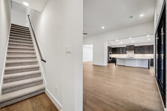 stairs featuring recessed lighting, baseboards, and wood finished floors