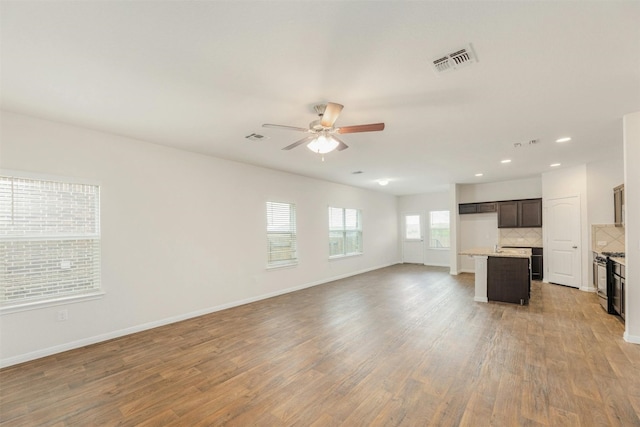 unfurnished living room featuring hardwood / wood-style flooring and ceiling fan