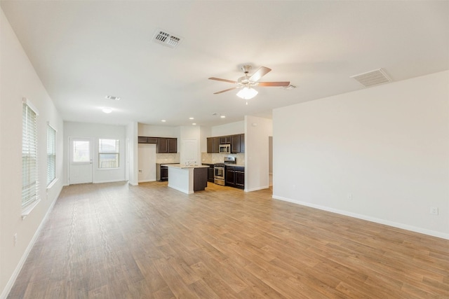 unfurnished living room featuring ceiling fan and light hardwood / wood-style flooring