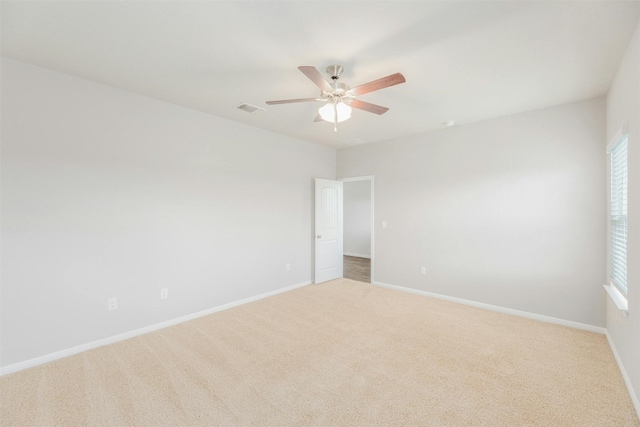 spare room featuring ceiling fan and light colored carpet