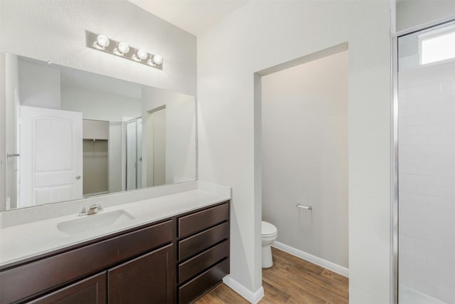 bathroom featuring hardwood / wood-style flooring, toilet, an enclosed shower, and vanity