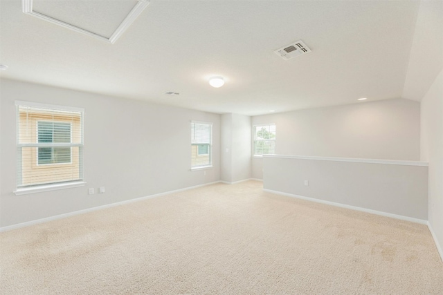 spare room with lofted ceiling and light carpet