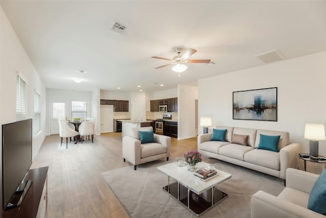 living room with ceiling fan and light wood-type flooring