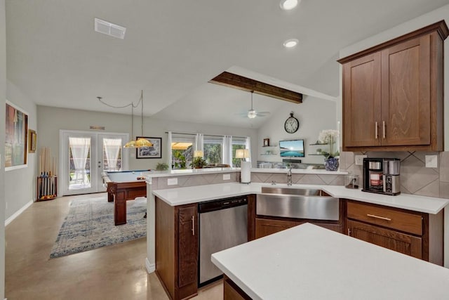 kitchen featuring a peninsula, finished concrete flooring, visible vents, stainless steel dishwasher, and a sink