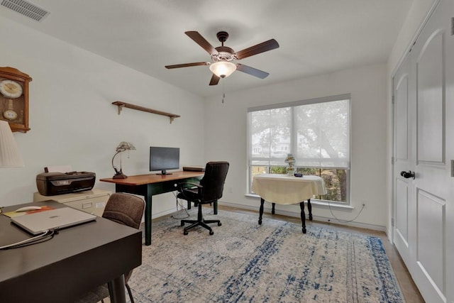 office space featuring visible vents, baseboards, wood finished floors, and ceiling fan