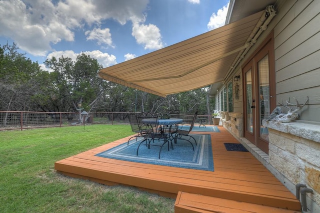 deck featuring outdoor dining space, a yard, and a fenced backyard