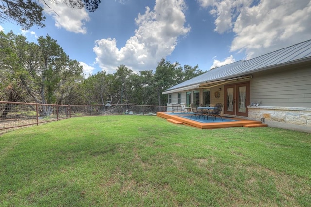 view of yard featuring french doors, a fenced backyard, and a deck