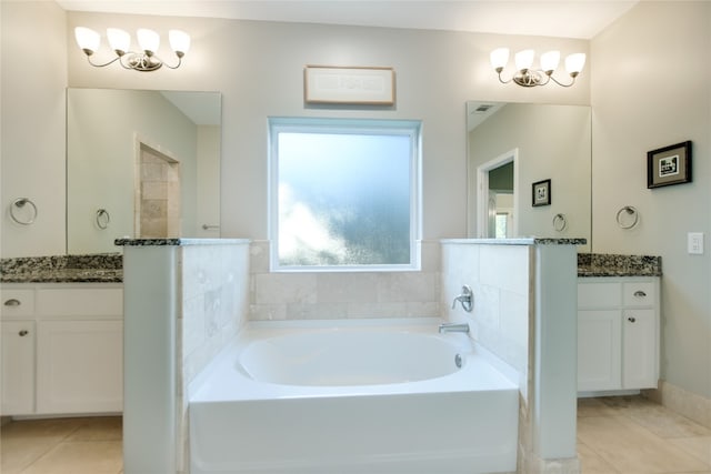 bathroom featuring tile floors, vanity, a washtub, and an inviting chandelier