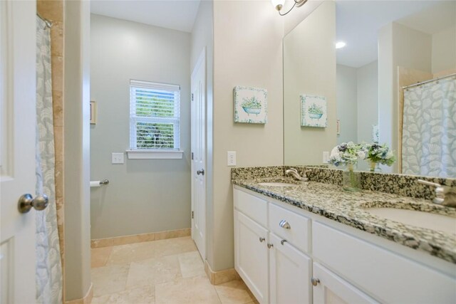 bathroom featuring tile flooring, vanity with extensive cabinet space, and dual sinks