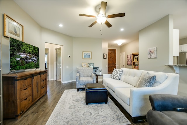 living room with dark wood-type flooring and ceiling fan