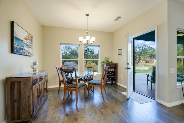 dining area featuring dark hardwood / wood-style floors and an inviting chandelier