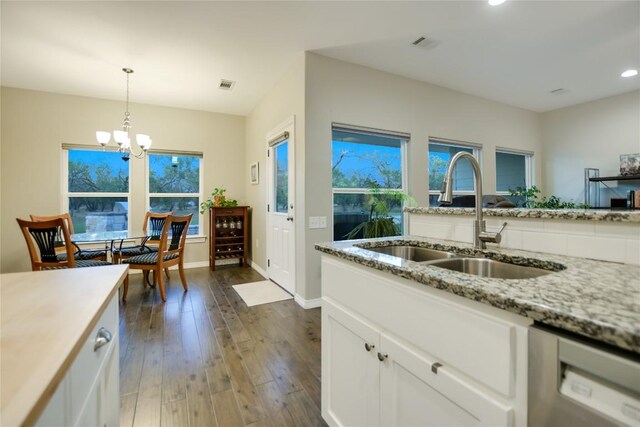 kitchen with white cabinetry, dark wood-type flooring, stainless steel dishwasher, a chandelier, and sink