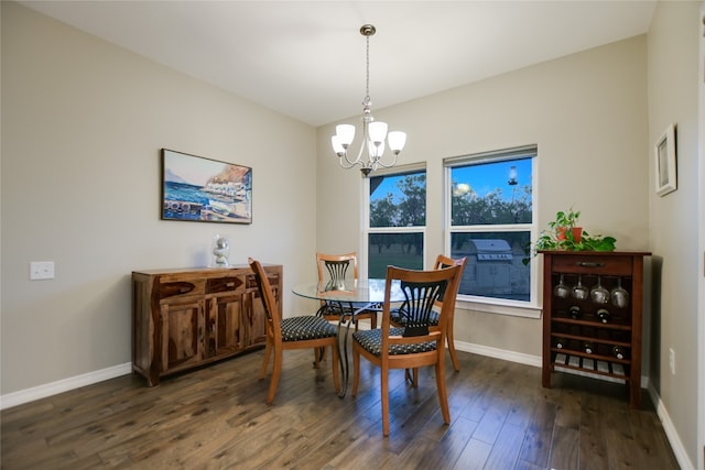 dining space featuring dark hardwood / wood-style floors and a chandelier