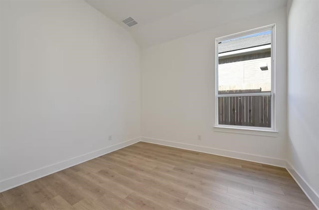 unfurnished room with lofted ceiling and light hardwood / wood-style flooring