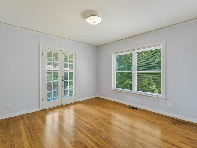 spare room featuring crown molding, french doors, and light wood-type flooring