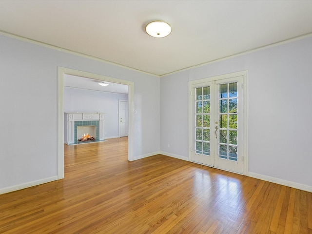 spare room with crown molding, light wood-type flooring, and french doors