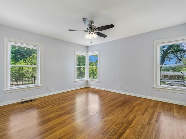 unfurnished room featuring hardwood / wood-style floors, plenty of natural light, and ceiling fan