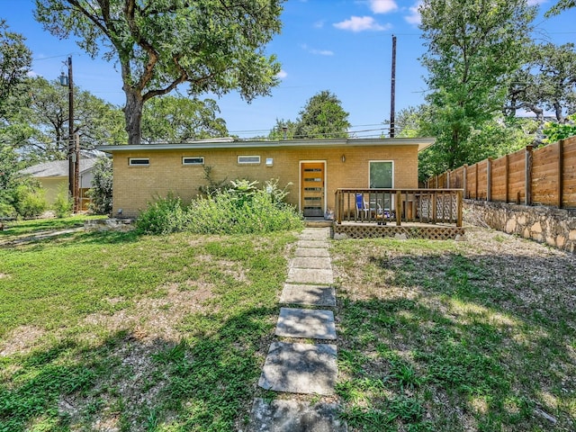 view of front of property featuring a wooden deck and a front lawn