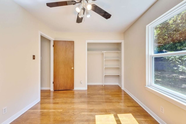 unfurnished bedroom with ceiling fan, a closet, and light hardwood / wood-style flooring