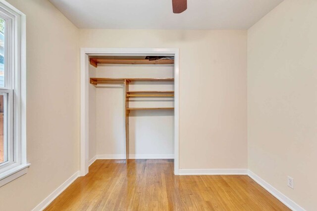 unfurnished bedroom featuring a closet, light hardwood / wood-style floors, and ceiling fan