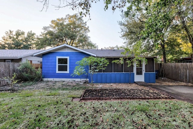 view of front of home featuring a sunroom and a front yard