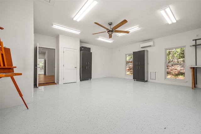 spare room featuring light speckled floor, ceiling fan, and a wall mounted AC