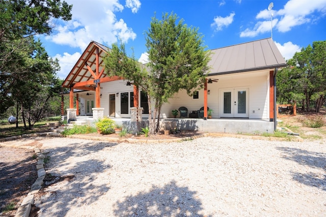 view of front of property with a ceiling fan, metal roof, a standing seam roof, covered porch, and french doors