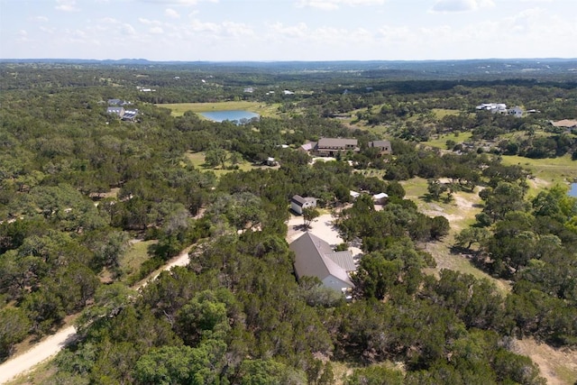 birds eye view of property featuring a water view and a wooded view