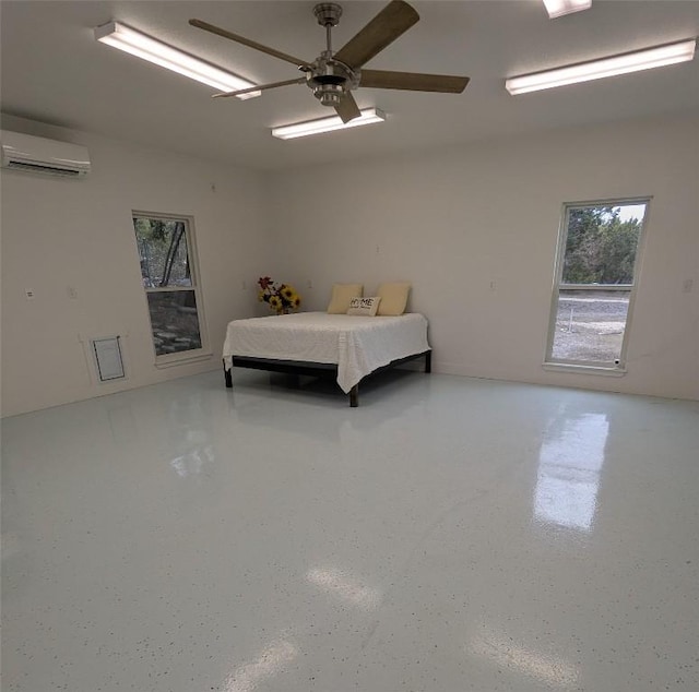 bedroom with speckled floor, a wall mounted AC, and a ceiling fan