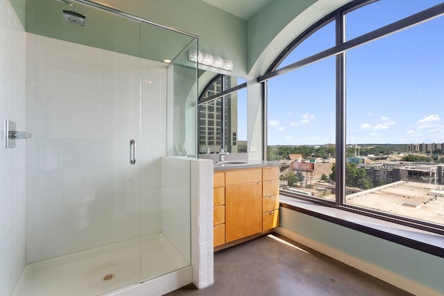 bathroom featuring concrete floors, a shower with shower door, and sink