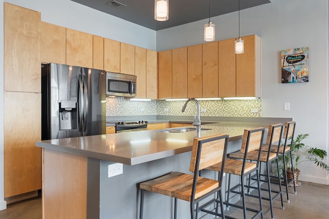 kitchen featuring stainless steel appliances, decorative light fixtures, a kitchen breakfast bar, decorative backsplash, and light brown cabinetry