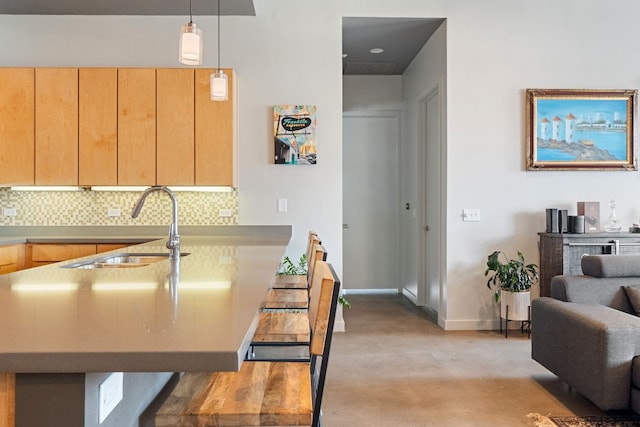 kitchen featuring sink, light brown cabinets, kitchen peninsula, pendant lighting, and backsplash