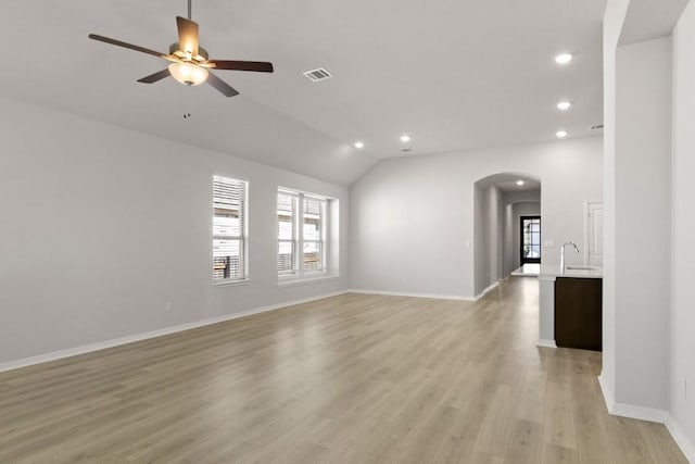 empty room with light hardwood / wood-style floors, sink, lofted ceiling, and ceiling fan