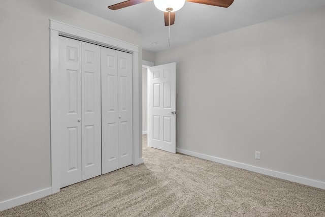 unfurnished bedroom featuring light colored carpet, a closet, and ceiling fan