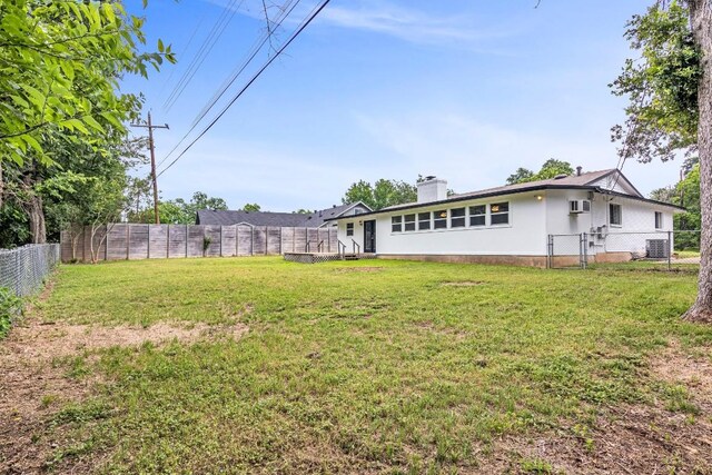 view of yard featuring an AC wall unit and central AC unit