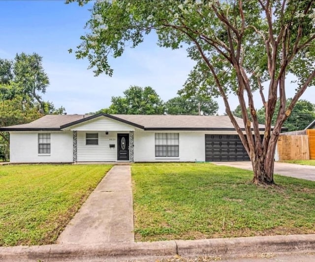 single story home featuring a front lawn and a garage