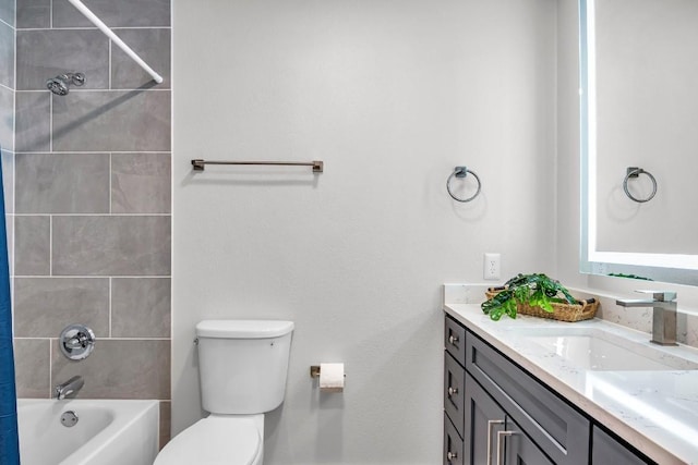 full bathroom featuring tiled shower / bath combo, toilet, and vanity