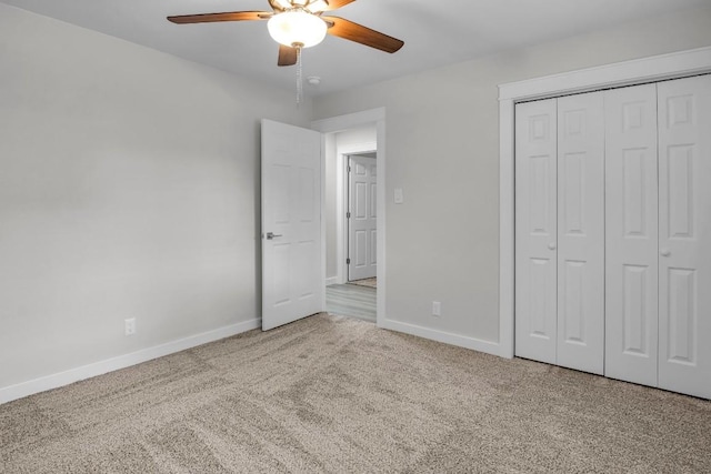 unfurnished bedroom featuring light carpet, a closet, and ceiling fan