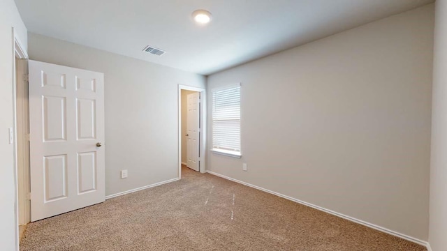 unfurnished room featuring light carpet