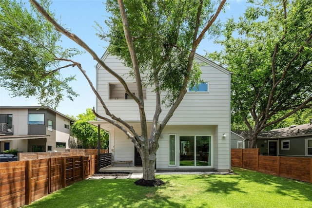 rear view of house featuring a lawn