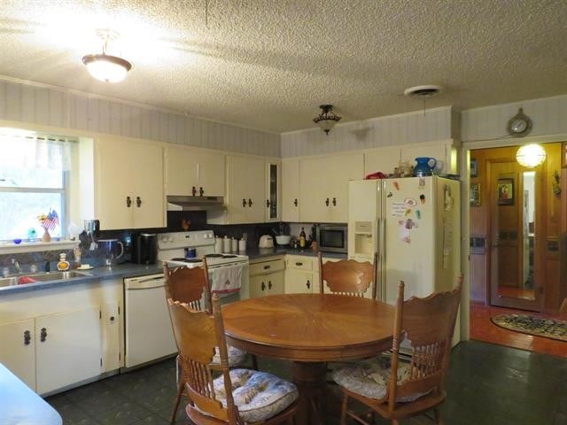 dining space featuring sink and dark tile patterned flooring