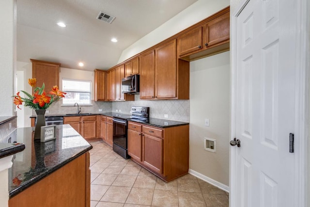253 Lear Ave, Buda, TX 78610 - kitchen with black / electric stove, decorative backsplash, stainless steel microwave, dark stone countertops, and lofted ceiling
